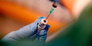 Amos García explica la deficiencias de de vacunas que padece Latinoamérica. En la foto un inyectadora sustrae el antiviral con guantes quirúrgicos como medida de protección,